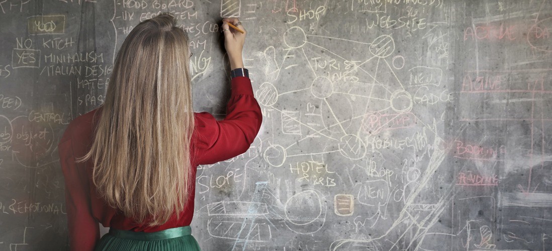 woman-in-red-long-sleeve-writing-on-chalk-board